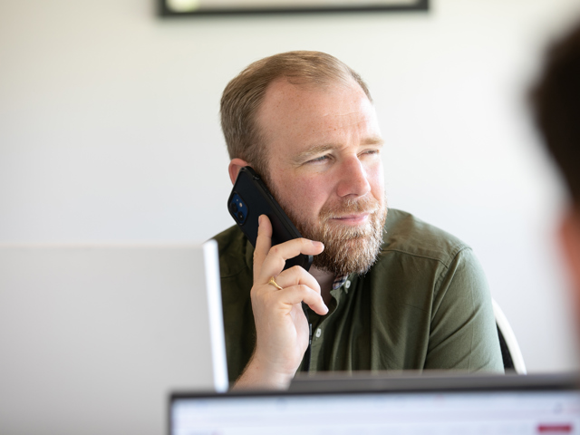 Recruitment consultant on phone in office at desk